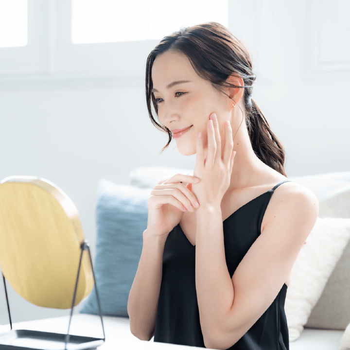 鏡を見て笑顔の女性