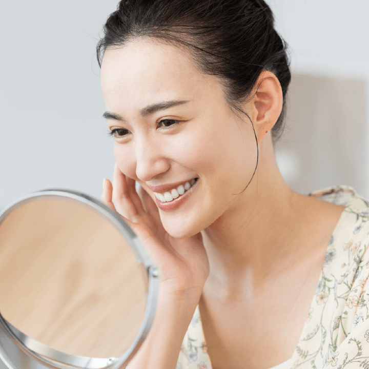 鏡を見て笑顔の女性